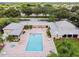 Aerial view of the pool with lounge chairs, mature landscaping, and recreational facilities at 4550 Pinebrook Cir # 505, Bradenton, FL 34209