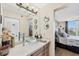 Bathroom featuring modern vanity, unique glass bowl sink, and a glimpse into the main bedroom at 4550 Pinebrook Cir # 505, Bradenton, FL 34209