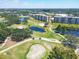 Aerial view of the golf course with lush greenery and water features, alongside residential buildings at 4550 Pinebrook Cir # 505, Bradenton, FL 34209
