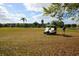 Picturesque golf course showcasing a player preparing to tee off, with a golf cart nearby and palm trees in the background at 4550 Pinebrook Cir # 505, Bradenton, FL 34209