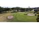 Aerial view of golfers on the green, bunkers, and a water feature, highlighting the course's layout and features at 4550 Pinebrook Cir # 505, Bradenton, FL 34209