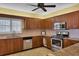 Modern kitchen with stainless steel appliances, wood cabinetry, and granite countertops at 4550 Pinebrook Cir # 505, Bradenton, FL 34209