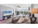 Bright living room featuring a plush sofa, scenic balcony views, and modern entertainment center at 4550 Pinebrook Cir # 505, Bradenton, FL 34209