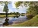 Scenic pond view reflecting the sky, surrounded by lush greenery and golf course at 4550 Pinebrook Cir # 505, Bradenton, FL 34209