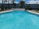 Community pool with clear blue water, surrounded by lounge chairs and palm trees at 4715 Bay Ne St # 119, St Petersburg, FL 33703