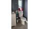 Compact bathroom featuring a toilet with a storage basket and a small window for natural light at 5830 Portsmouth Dr, Tampa, FL 33615