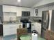 Bright kitchen featuring white cabinets, granite countertops, and stainless steel appliances at 5830 Portsmouth Dr, Tampa, FL 33615
