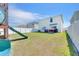 Spacious backyard featuring a large grassy area, patio seating, and a white fence at 636 Sunlit Coral St, Ruskin, FL 33570