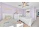 Inviting bedroom with two twin beds, soft lavender walls, and a stylish ceiling fan at 636 Sunlit Coral St, Ruskin, FL 33570