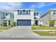 Charming two-story home featuring a blue garage door, shutters, and manicured landscaping at 636 Sunlit Coral St, Ruskin, FL 33570