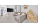 Cozy living area with gray sectional, television, and a dollhouse, perfect for Gathering time at 636 Sunlit Coral St, Ruskin, FL 33570