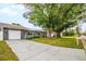 Single-story home featuring a stone-accented garage, solar panels, a well-kept lawn, and a long driveway at 7111 13Th E St, Sarasota, FL 34243