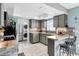 Bright kitchen boasts a tiled backsplash, gray cabinets, stainless steel appliances, and a breakfast bar at 7111 13Th E St, Sarasota, FL 34243