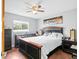 Comfortable main bedroom with a dark wood furniture set, ceiling fan and lots of natural light at 7111 13Th E St, Sarasota, FL 34243
