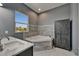 Bathroom featuring a soaking tub, and neutral grey tiling provides a luxurious spa-like feel at 718 S 22Nd St, Tampa, FL 33605