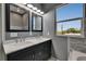 Double vanity bathroom featuring two mirrors, modern lighting and fixtures, and a street view window at 718 S 22Nd St, Tampa, FL 33605