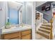 Half bath featuring wood cabinets, white sink and blue accent wall at 8125 Stone Path Way, Tampa, FL 33647
