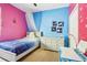 Charming bedroom featuring whimsical decor, a canopy bed, and a bright pink and blue color scheme at 8125 Stone Path Way, Tampa, FL 33647