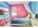 Whimsical bedroom featuring pink accent wall, large screen tv, window, and canopy bed at 8125 Stone Path Way, Tampa, FL 33647