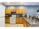 Kitchen with a sink, tile floors, speckled granite countertops, oak cabinets and white appliances at 8125 Stone Path Way, Tampa, FL 33647