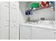 Functional laundry room with a washer, dryer, storage shelves, and a closet at 8125 Stone Path Way, Tampa, FL 33647