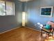 Cozy bedroom features light wood floors, a striking floor lamp and comfortable chair at 825 S Village N Dr # 201, St Petersburg, FL 33716