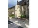 Building exterior with a rounded wall entrance, mature landscaping, a parking spot, and the address 825 at 825 S Village N Dr # 201, St Petersburg, FL 33716