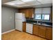 Bright kitchen featuring white appliances, wood flooring, and ample cabinet space at 825 S Village N Dr # 201, St Petersburg, FL 33716