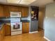 A functional kitchen design featuring wood cabinets, efficient appliances and ample countertop space at 825 S Village N Dr # 201, St Petersburg, FL 33716