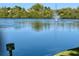 Beautiful tranquil view of a pond and fountain with lush vegetation and a sign stating 