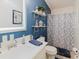 Stylish bathroom with a blue accent wall, modern fixtures, and decorative shelving at 8444 Fantasia Park Way, Riverview, FL 33578