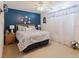 Cozy bedroom with blue accent wall, floral bedding, bedside lamps, and sheer curtains at 8444 Fantasia Park Way, Riverview, FL 33578