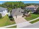 Aerial view of home featuring manicured lawn, mature palm trees, and a paved driveway at 8628 Eagle Brook Dr, Land O Lakes, FL 34638