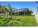 Spacious backyard with a screened-in pool, palm trees and privacy fence offers outdoor enjoyment at 8628 Eagle Brook Dr, Land O Lakes, FL 34638