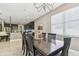 Dining area with dark wood furniture, modern chandelier, view into kitchen with breakfast bar seating at 8628 Eagle Brook Dr, Land O Lakes, FL 34638
