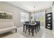 This dining room features a stylish chandelier, neutral color palette, and a window overlooking the outdoors at 8628 Eagle Brook Dr, Land O Lakes, FL 34638
