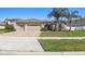 Nice single-Gathering home featuring a three-car garage, tidy landscaping, and mature palm trees at 8628 Eagle Brook Dr, Land O Lakes, FL 34638