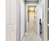 Hallway leads to laundry area and office, featuring tile flooring, and multiple white doors for storage at 8628 Eagle Brook Dr, Land O Lakes, FL 34638
