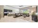 Spacious living room with kitchen island, leather sectional sofa, tile floors, and natural light at 8628 Eagle Brook Dr, Land O Lakes, FL 34638
