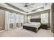 Spacious primary bedroom with tray ceiling, large windows, and neutral color palette for a relaxing retreat at 8628 Eagle Brook Dr, Land O Lakes, FL 34638