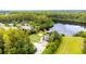 Aerial view of a community park with a playground, lakeside dock, lawn area, and trees at 8628 Eagle Brook Dr, Land O Lakes, FL 34638