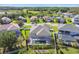 This aerial view shows a home with a screened-in pool, manicured lawn, palm trees, and white picket fence at 8628 Eagle Brook Dr, Land O Lakes, FL 34638