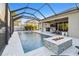 An inviting screened pool area complete with fire pit, outdoor furniture, and a covered patio at 8628 Eagle Brook Dr, Land O Lakes, FL 34638