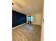 A living room with wood-look tile flooring and a dark blue accent wall at 9618 N 13Th St, Tampa, FL 33612