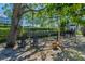 Serene backyard with mature trees providing shade and an inviting seating area at 985 Wellington Ct, Dunedin, FL 34698