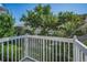 Outdoor balcony area with white railing and views of lush greenery at 985 Wellington Ct, Dunedin, FL 34698