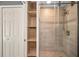 Contemporary bathroom featuring tiled shower, glass door, and built-in shelves at 985 Wellington Ct, Dunedin, FL 34698