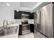 Updated kitchen with stainless steel appliances, dark cabinetry, and quartz countertops at 985 Wellington Ct, Dunedin, FL 34698