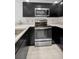Close-up of the kitchen's stainless steel oven, cooktop, and microwave appliances at 985 Wellington Ct, Dunedin, FL 34698