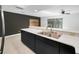 Modern kitchen island with quartz countertops, stainless steel sink, and dark cabinetry at 985 Wellington Ct, Dunedin, FL 34698